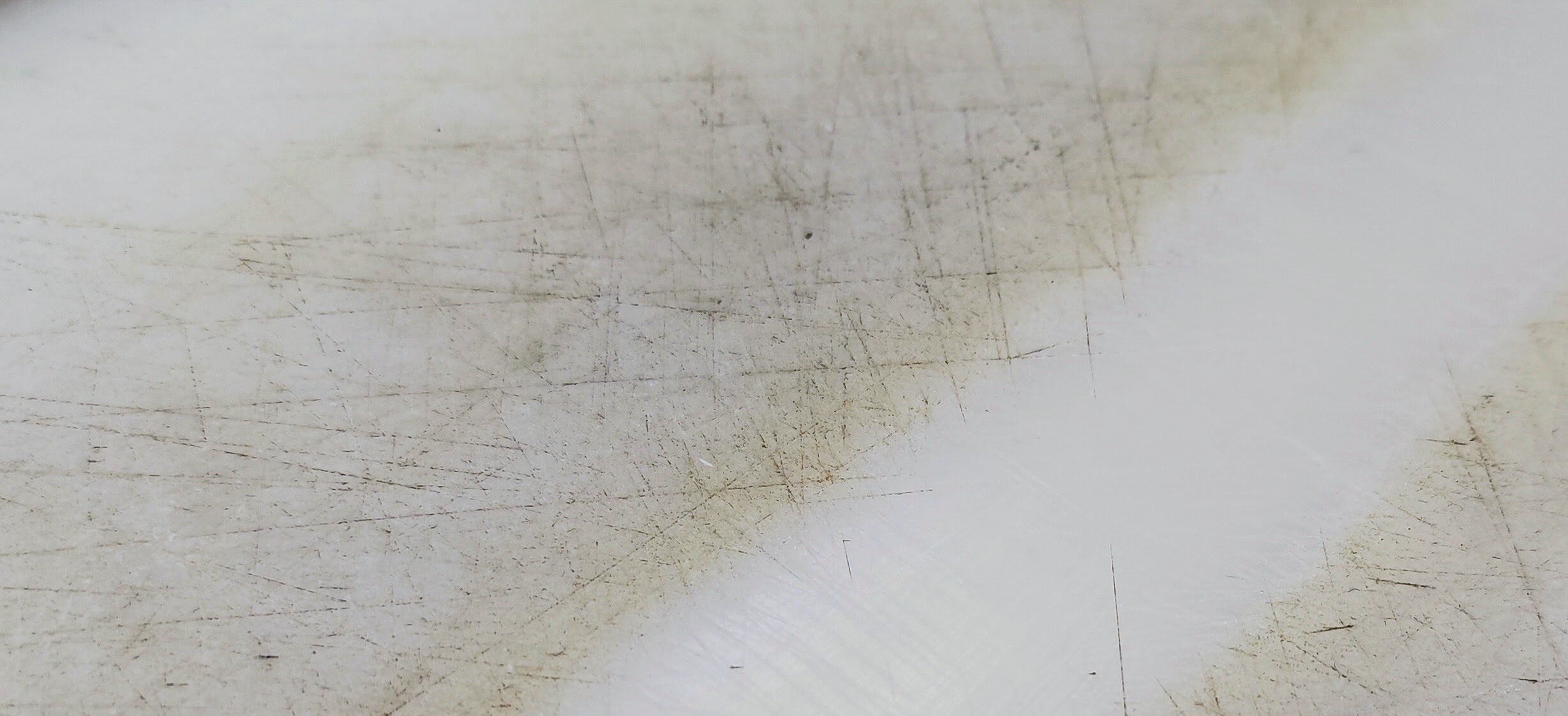 So sieht früher oder später jedes Schneidebrett aus Kunststoff aus. In den Schnittspuren sammeln sich Partikel die unangenehm riechen und es entstehen Flecken. In der Mittel wurde die Oberfläche bereits mit dem Hygiene-Schaber regeneriert.